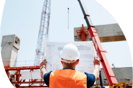 A professional builder holding a blueprint with ongoing construction in the background, highlighting the importance of a builders insurance quote from Be Covered Insurance for comprehensive coverage including indemnity and liability insurance.