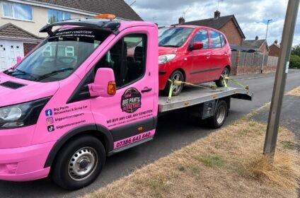 red car on the pink removal truck